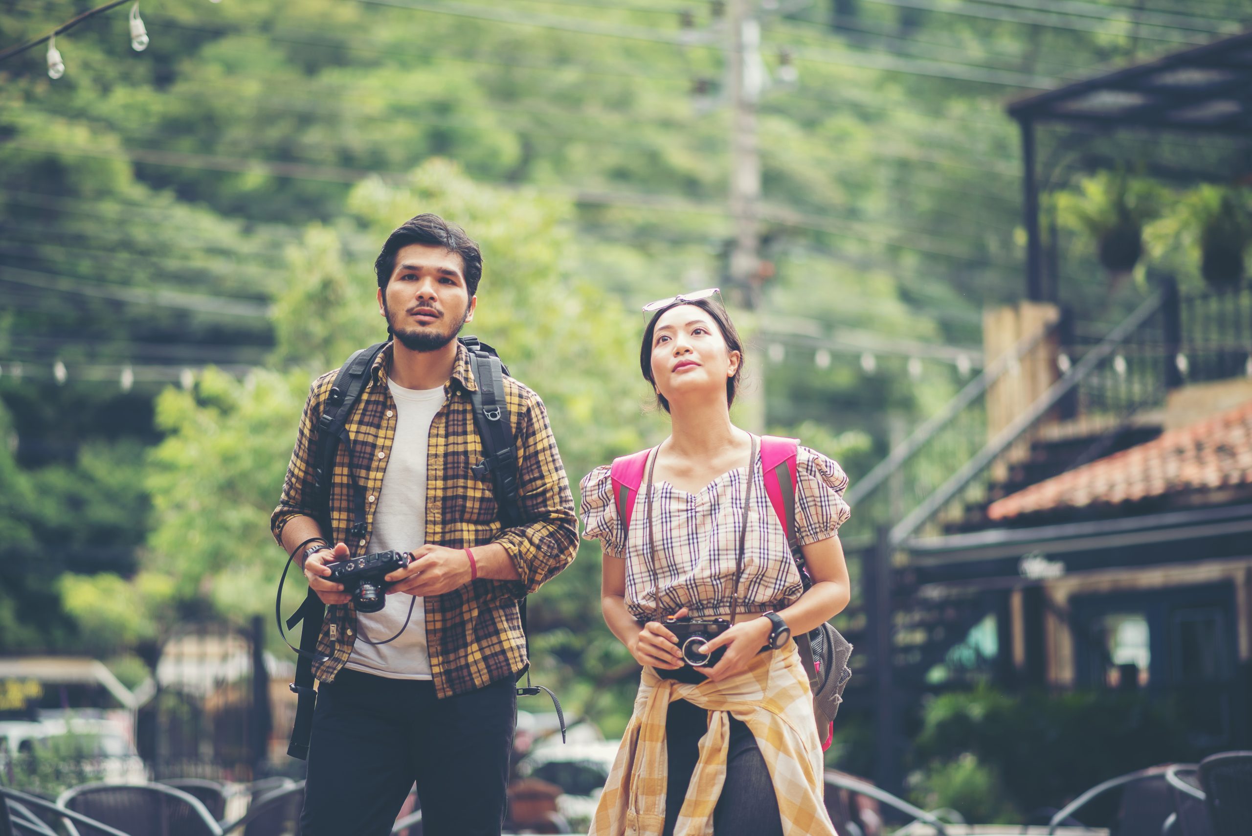 Happy young backpacker couple take a walk together on the street while take photo on holiday time.